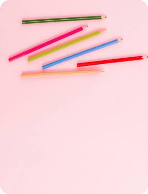 Colored pencils on a pink background