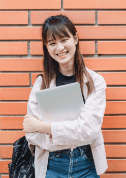 A student smiling with a laptop