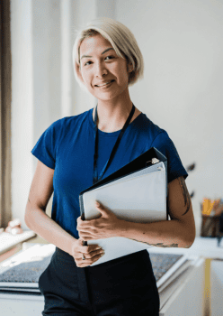 An administrator holding a folder and smiling