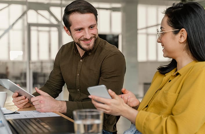 Two colleagues smiling with a phone