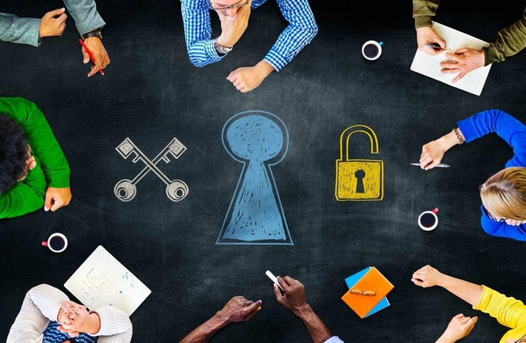 A group of people sitting around a table looking at images of locks and keys